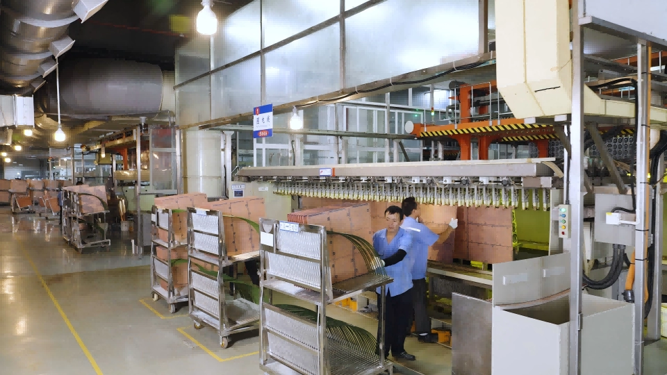 worker operating pcb pattern-plating equipment with panels in a production area. Worker operating PCB pattern-plating equipment with panels in a production area.