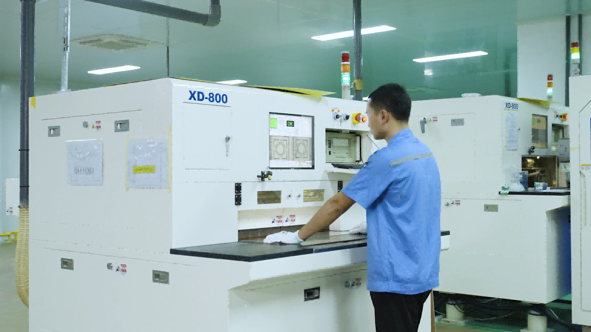 Operator working at an X-ray target drilling machine in a PCB production area.